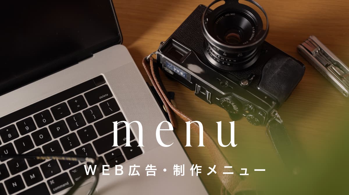 WEB広告・制作メニュー — ノートPCとカメラが置かれたデスク